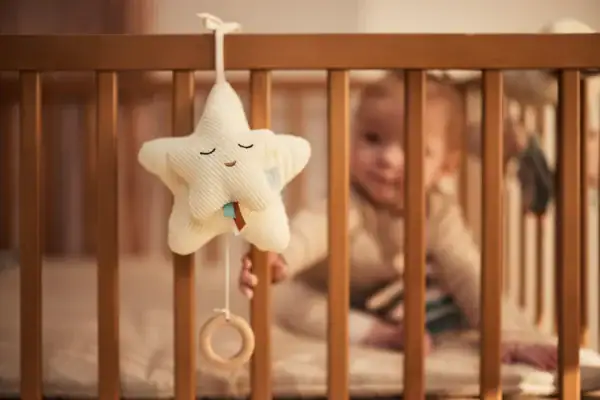 Babybedje met Jollein sterrenmuziek hanger in ivoor, zacht en veilig voor baby's slaap.